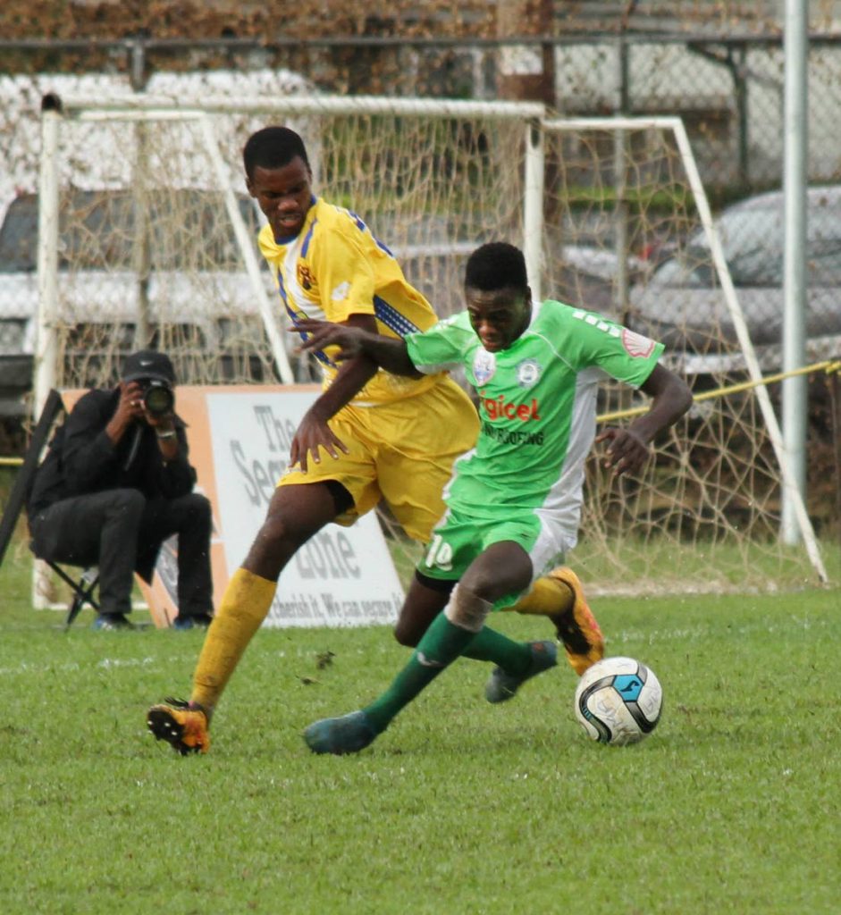 Carapichaima East Secondary’s Dexter Neils,right, is challenge by Fatima’s Saeed Pompy Charles for the ball as the two teams met yesterday, at Fatima Grounds,Mucurapo.