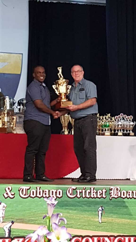 Miabah Uthman of Police, left, collects the 2017 Cricketer of the Year award on behalf of Dane Teelucksingh, from vice-chairman of the North Zonal Council Andrew Hirst.