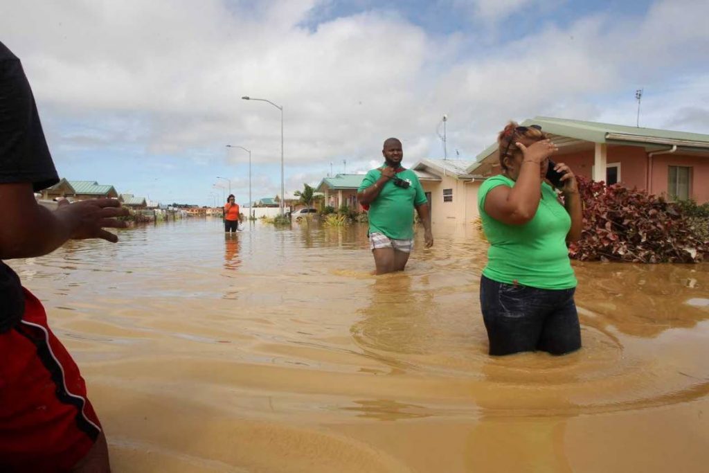 Flood victims wade through waters at Greenvale.