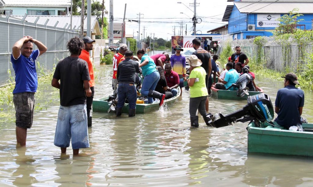 WATER ACTIVITIES: Community mobilised with boats and relief items, come to the aid of their fellow residents of the El Socorro South community yesterday which has been under water for the last five days.