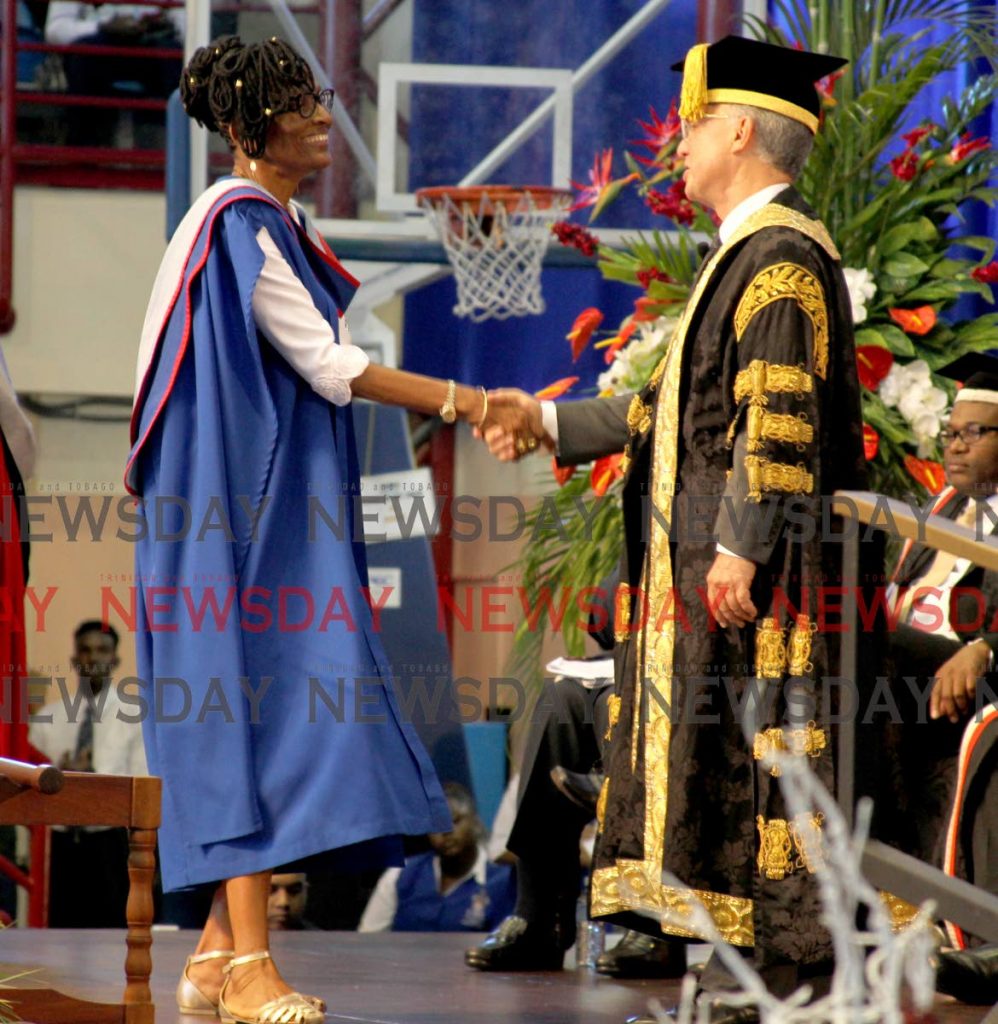 UWI chancellor Robert Bermudez congratulates Elizabeth Montano, mother of soca superstar Machel Montano, on her Master of Philosophy in Cultural Studies at the Faculty of Humanities and Education graduation, UWI, St Augustine yesterday. PHOTO BY ROGER JACOB