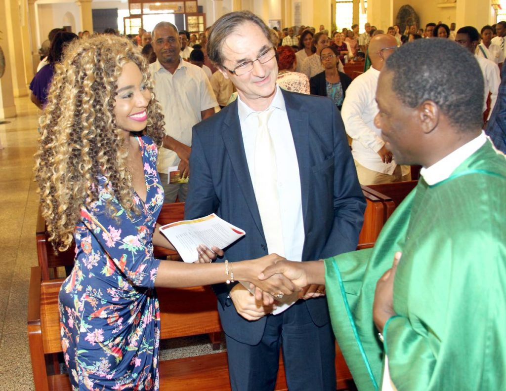 “Que la paix soit avec toi’ (Peace be with you).” Chief Celebrant Monsignor Julien Kabore, counsellor of Apostolic Nunciature, greets French Ambassador to TT Serge Lavroff and his wife  Caroline, at yesterday’s inaugural French Holy Eucharist Mass at the Cathedral of the Immaculate Conception, Port of Spain.