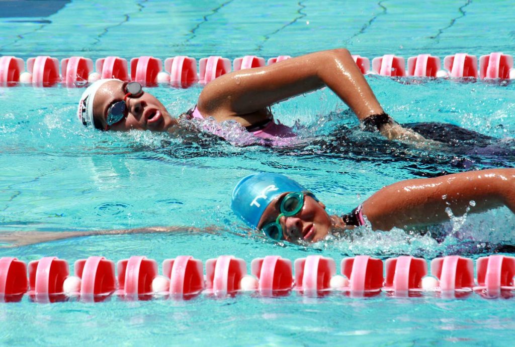 Amy Pounder(background) and Ashley Scott of St Joseph Convent Port of Spain take part in the National Aquathlon School Championships, which took place at the National Aquatic Centre, Couva, yesterday.