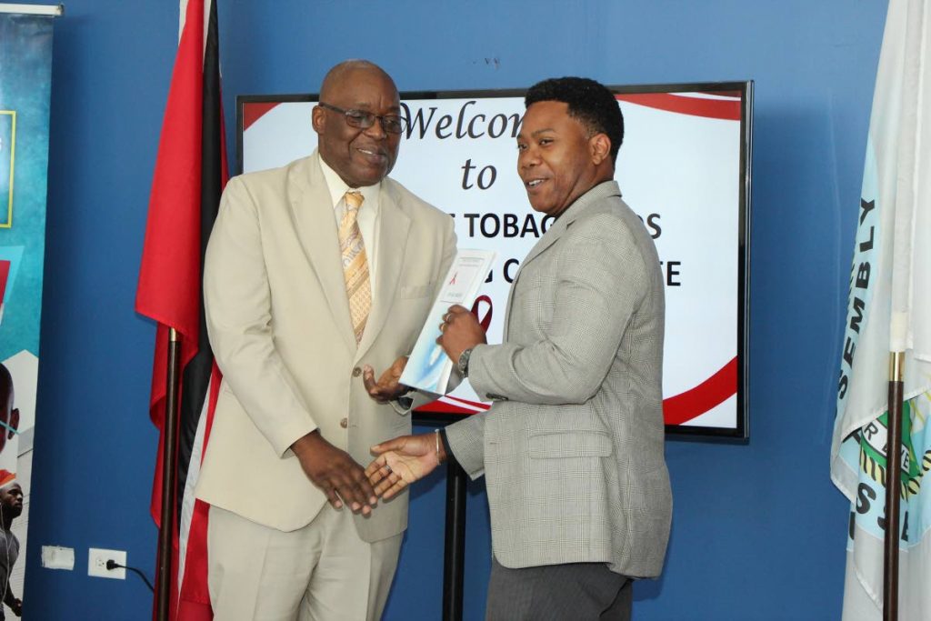Kelvin Charles, left, Chief Secretary of the THA, presents the instrument of appointment to Dr Kale Ferguson, Chairman of Tobago Aids Coordinating Committee. 
