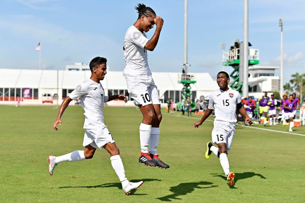 TT’s Judah Garcia leaps with a clenched fist as he celebrates his game-winner against St Vincent/Grenadines yesterday. Also in photo are Mark Ramdeen (left) and John-Paul Rochford. PHOTO COURTESY CONCACAF.