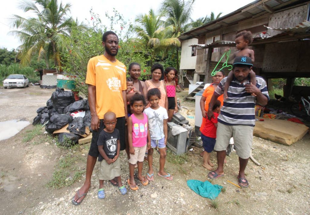 Still need help: Members of the Williams family, from left, Nigel George, Kizzy Williams, Stacey Pierre, Kadisha Williams with children Precious, Issiah, Angel, Elijah, Enrique and Liam, and Kenrick Pierre, right, at Riley Land Settlement, Sangre Grande on Friday. The family was one of many affected by devastating floods on October 19. PHOTOS BY ROGER JACOB