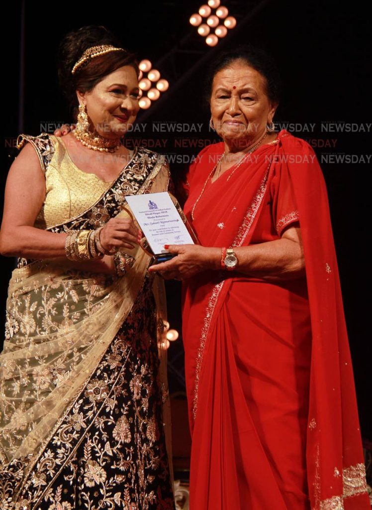 File Photo of Opposition Leader Kamla Persad-Bissessar presents a plaque on behalf of the NCIC to Sakunti Ramnarinesingh for her contribution in reforming the role of women in business and community service. The awards function took place at the Divali Nagar, Chaguanas last November. 
