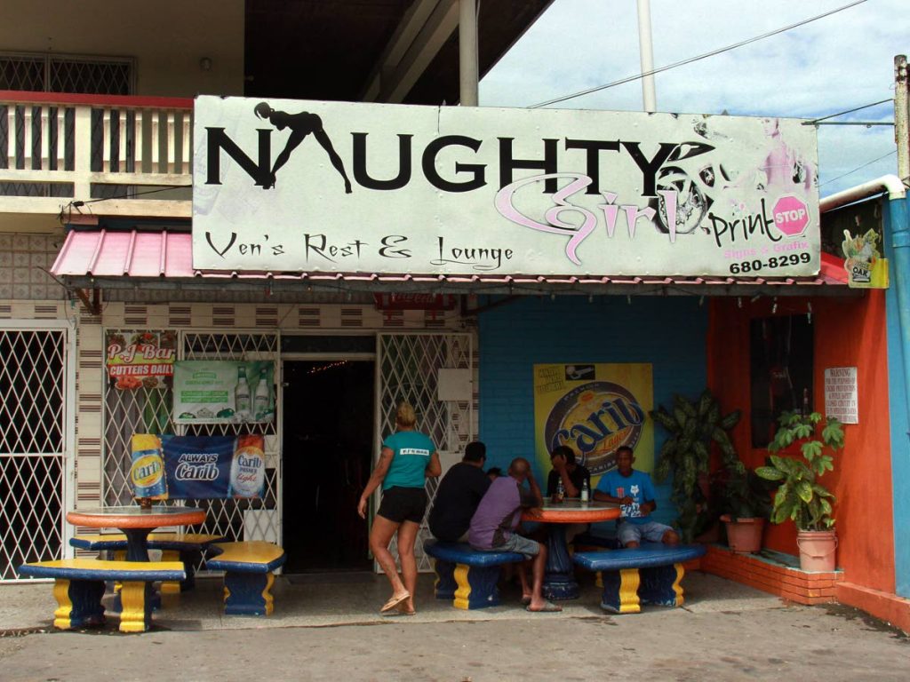 Patrons sit outside Naughty Girl  Ven’s Rest & Lounge, Union Road, Marabella, yesterday, where Shazard Abdool was shot and killed on Friday night. PHOTO BY ANIL RAMPERSAD