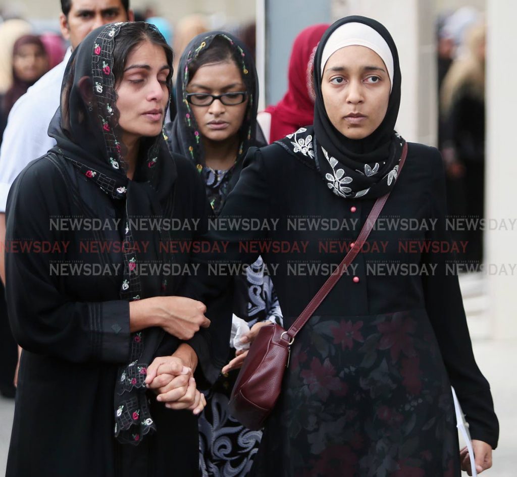 Naseema Ali is consoled by relatives at the funeral of her mother Haseena Ali held at the  Masjid-un-Nur, Carapichaima yesterday. Haseena Ali was stabbed to death in her home at Freeport on Friday. PHOTOS BY AZLAN MOHAMMED.