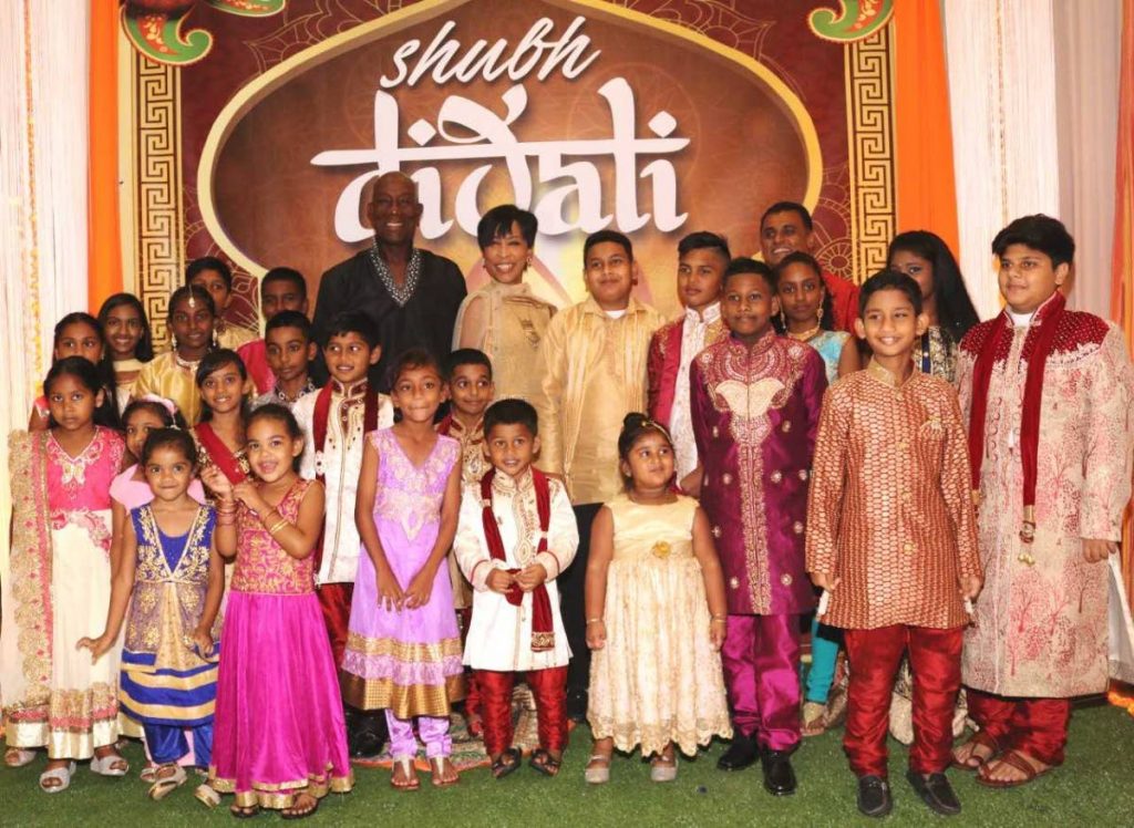 DIVALI DELIGHT: Prime Minister Dr Keith Rowley and his wife Sharon pose for a picture with some of their younger guests at a Divali function hosted at the Diplomatic Centre in St Ann’s yesterday.