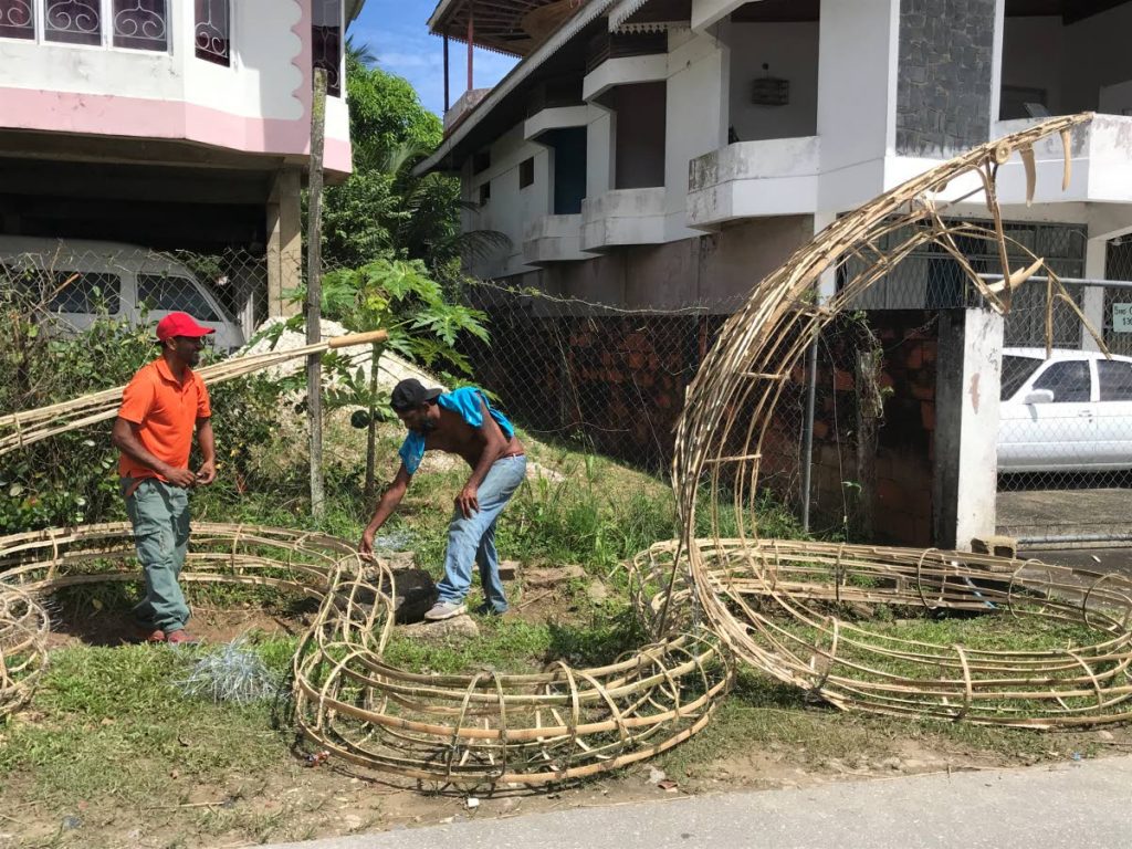 Marvin Mahadeo, one of the Patna festival organisers, and another volunteer, bend wire around bamboo to form a cobra as they prepare to light deyas in celebration of Divali. Photo by Sarika Bhaggeratty