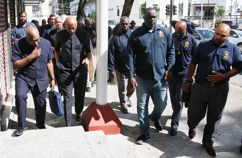 OWTU’s Ozzie Warwick, at left ,chats with president general Ancil Roget as they and other members enter the Industrial court Port of Spain on November 7.