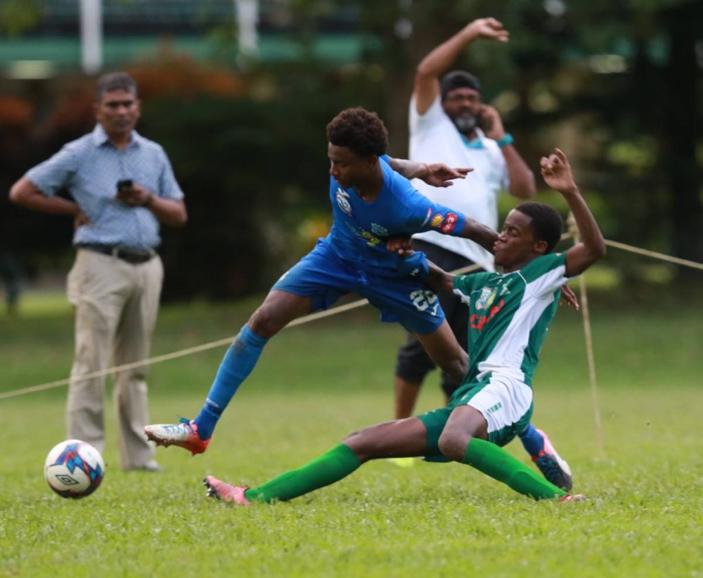 Naparima College's Seon Shippley (left) tries escape a challenge from  Trinity Moka's Adel Black-Haynes during the SSFL match at the Trinity grounds,yesterday. Photo by Nicholas Bhajan/CA-images
