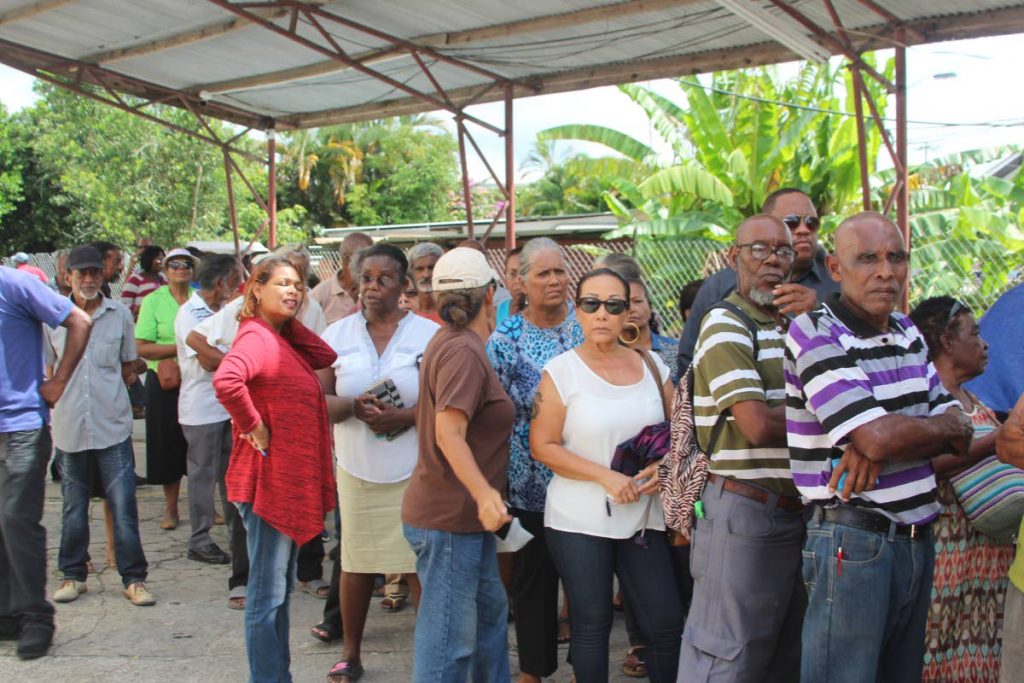 STARTING OVER: Flood-hit residents of Sangre Grande wait to collect grants from the Social Development Ministry at the Sangre Grande Regional Corporation yesterday.