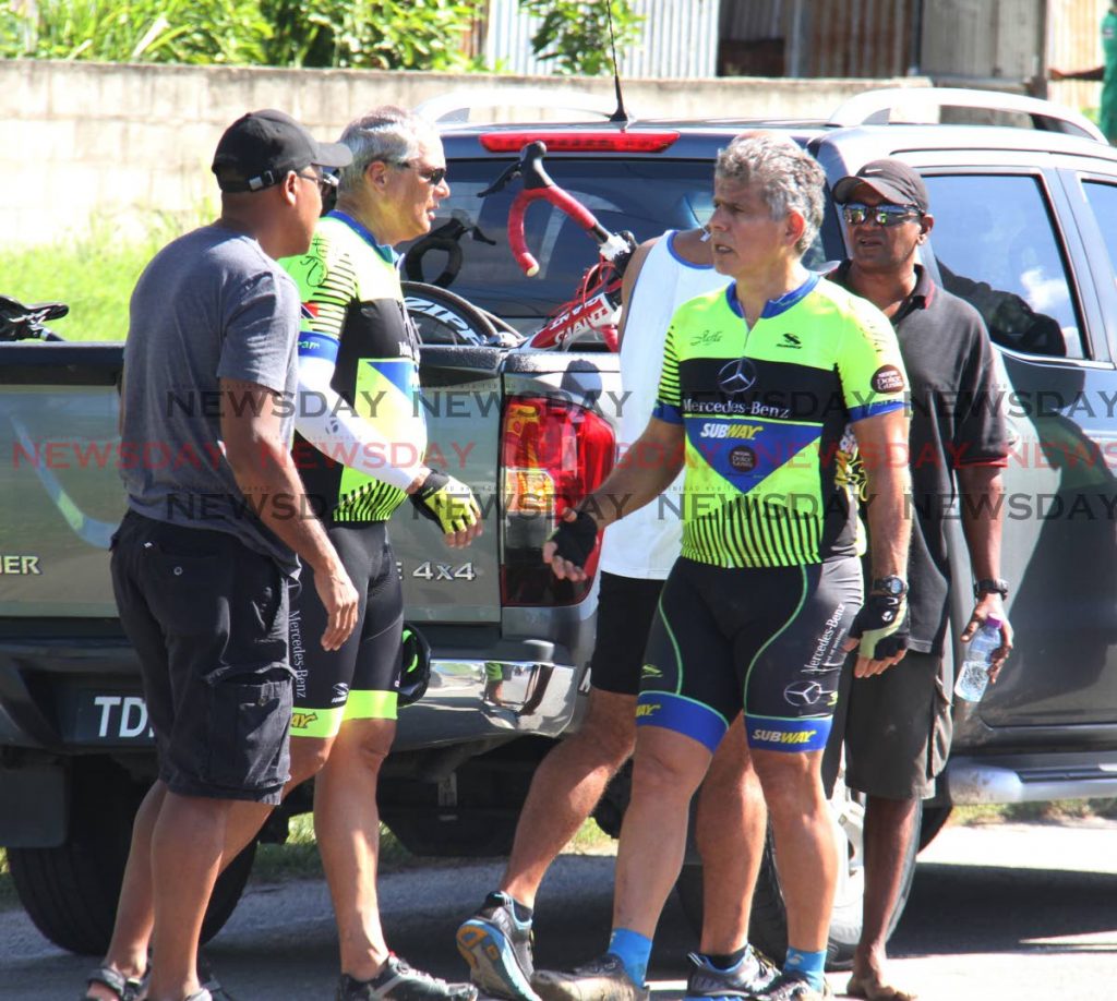 Members of Slipstream Cycling Club at the scene of an accident on Beetham Highway, near Beetham Gardens, where a driver crashed into the group, killing chef Joe Brown and bpTT employee Joanna Banks yesterday. PHOTO BY ROGER JACOB