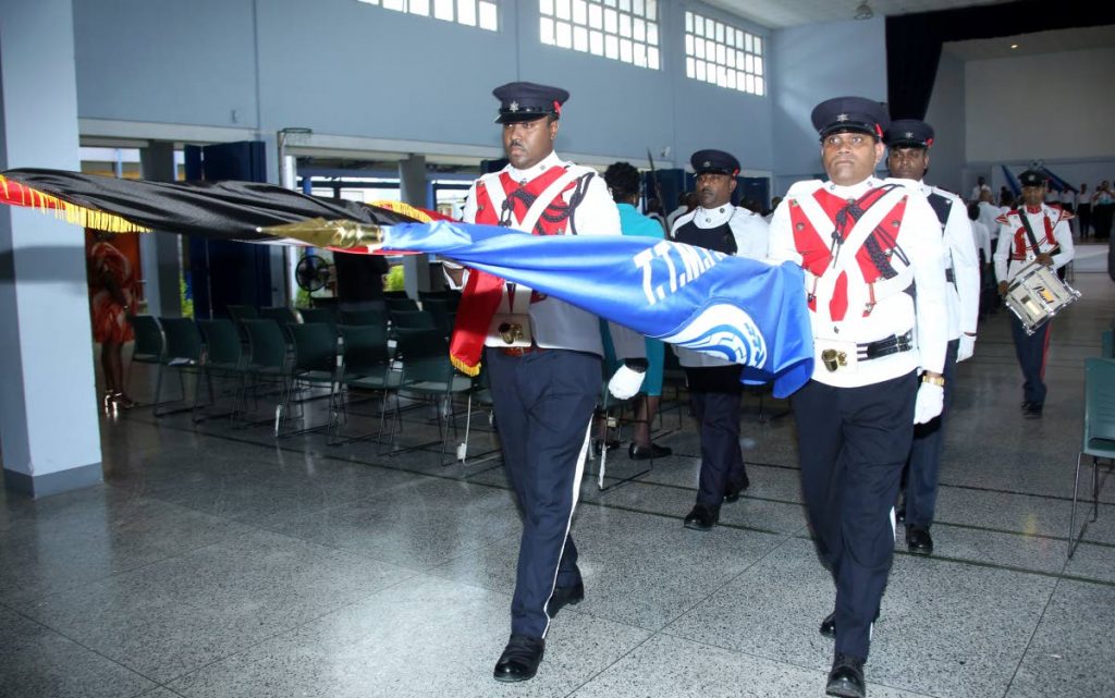 Officers of the  colour party  leave the auditorium at the end of the  TT Municipal Police Service interfaith service held at Marabella Secondary School yesterday. Photo by Vashti Singh