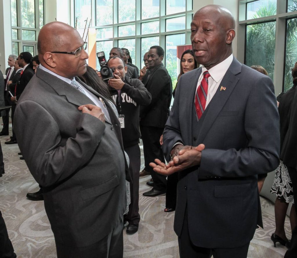 IT WASN’T ME: Prime Minister Dr Keith Rowley speaks with former government minister Conrad Enill at the gas symposium at the Hyatt in Port of Spain yesterday.