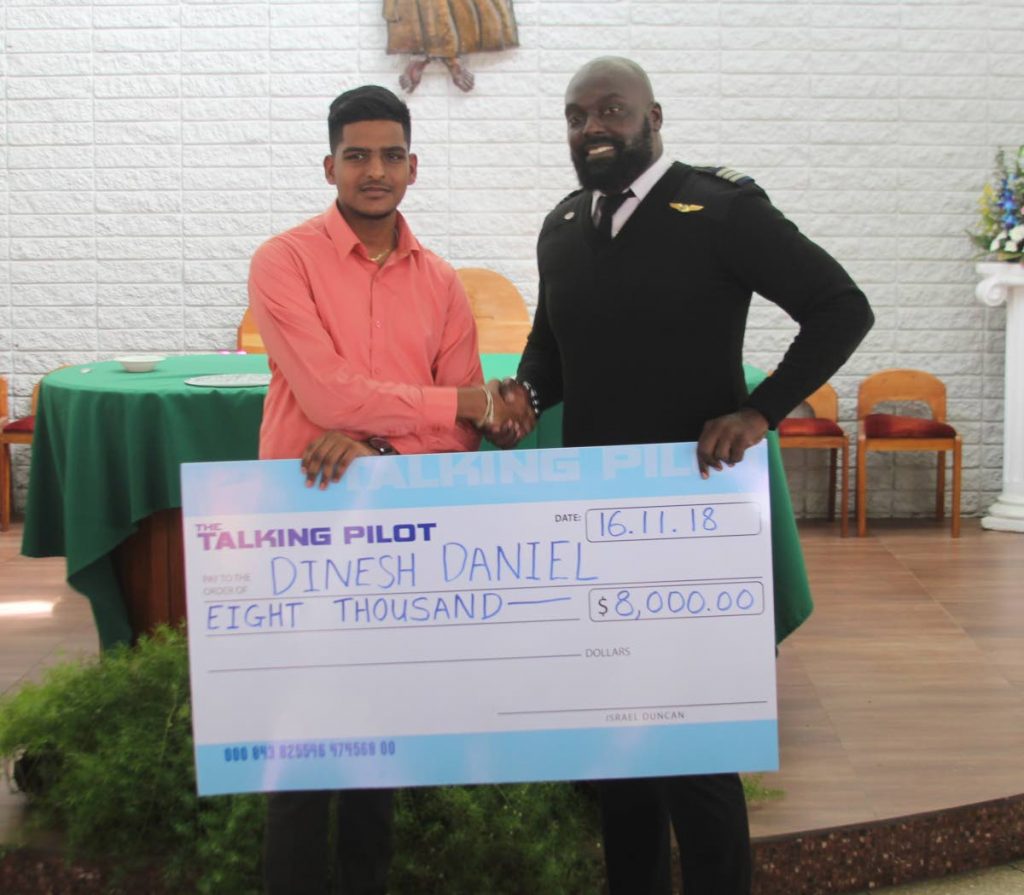 Israel Duncan, right, presents Dinesh Daniel with a cheque for $8,000 at an award ceremony at Holy Cross College, Arima on Friday.