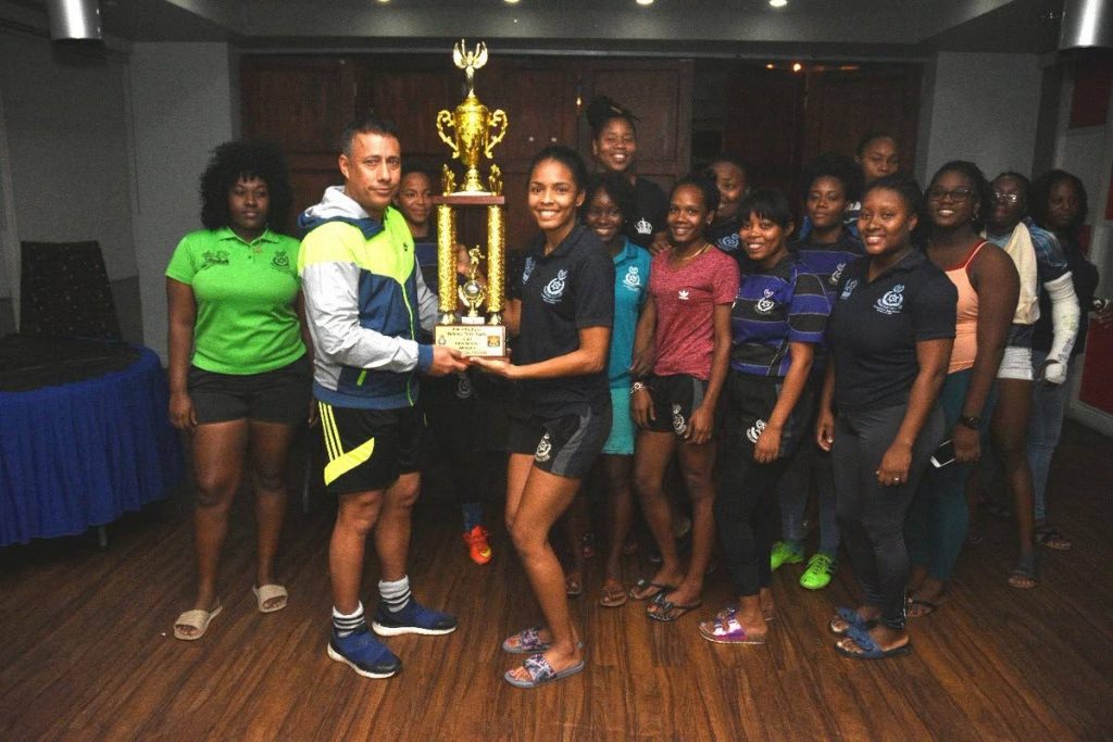 Commissioner of Police Gary Griffith presents the Police women's rugby team with a trophy after they won the annual Inter-Service Cup. 
