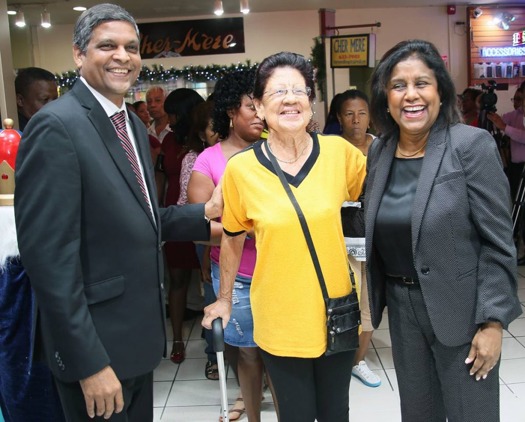 First customer: Dave Paladee, Pennywise Cosmetics managing director and CEO, and Trade Minister Paula Gopee-Scoon welcome Maureen Christopher (centre) the first customer at the newly opened Pennywise Cosmetics store in Long Circular Mall, St James. Photo by Azlan Mohammed