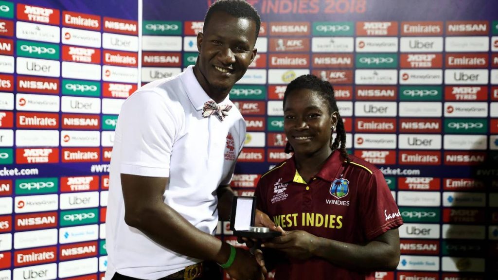 Former West Indies captain Darren Sammy, left, presents Windies women's star Deandra Dottin with the player of the match award after leading the team to victory over England on Sunday in Group B of the World T20 tournament at the Darren Sammy Stadium, St Lucia.