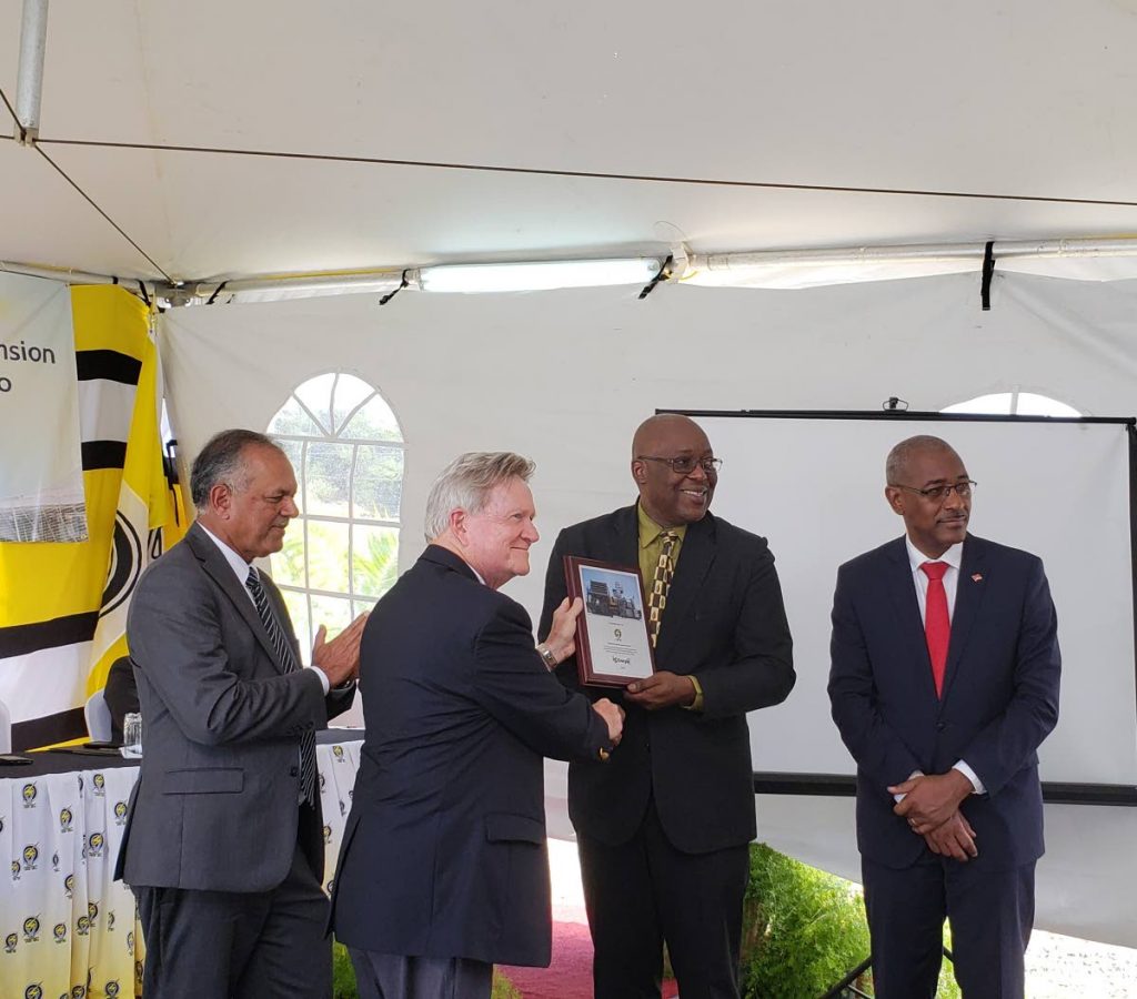 THA Chief Secretary Kelvin Charles, second from right, is presented with a plaque by a representative from LS Energia Inc, project consultants for the expansion of capacity for T&TEC’s Cove Power Plant at the commissioning on Monday. Looking at right is Minister of Public Utilities Robert Le Hunte and T&TEC’s Chairman Keith Sirju.↔PHOTOS BY Kinnesha George-Harry