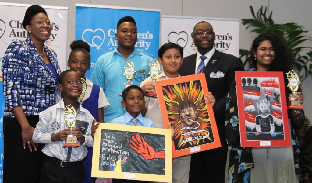 BUDDING ARTISTS: Children’s Authority director Safiya Noel and chairman Hanif Benjamin pose with winners of the authority’s video and art competition at the Hyatt, Port of Spain on Tuesday.