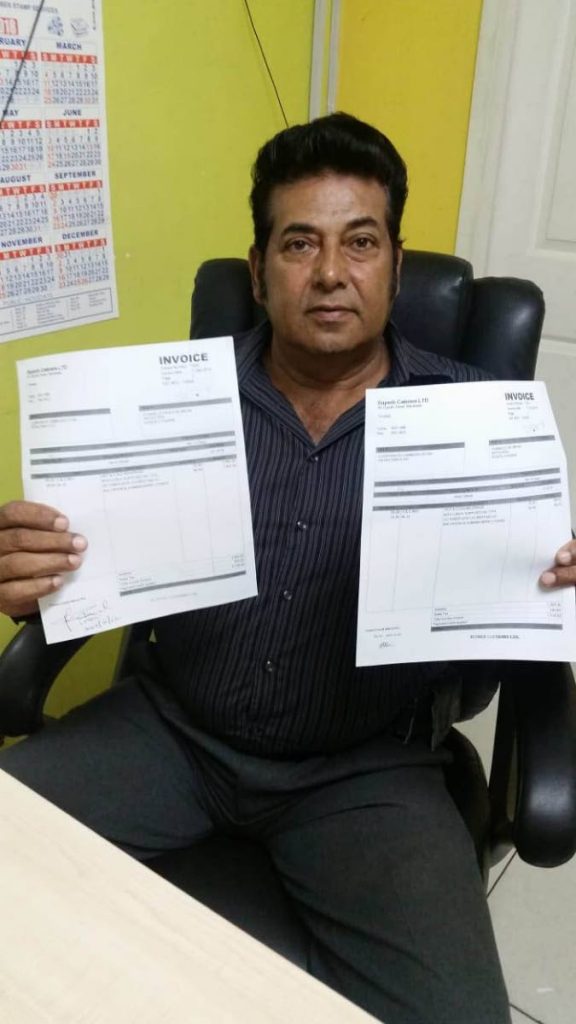 UPSET: Wayne Ali, managing director of Superb Caterers displays invoices for jobs done at Petrotrin.   PHOTO BY YVONNE WEBB