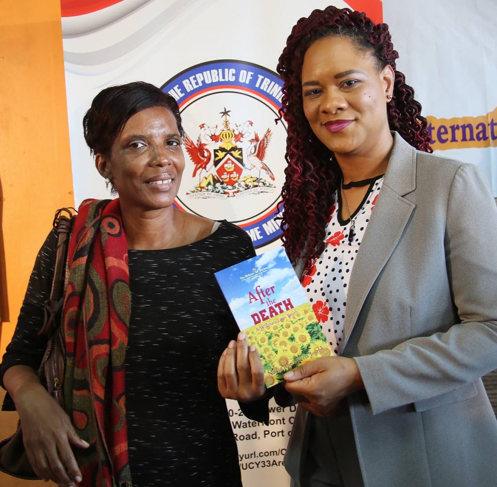 MY STORY: Domestic violence survivor Nadia Ann Narcis, left, presents a copy of her book After the Death to Minister in the office of the Prime 
Minister Ayanna Webster-Roy yesterday at City Gate in Port of Spain. PHOTO BY AZLAN MOHAMMED