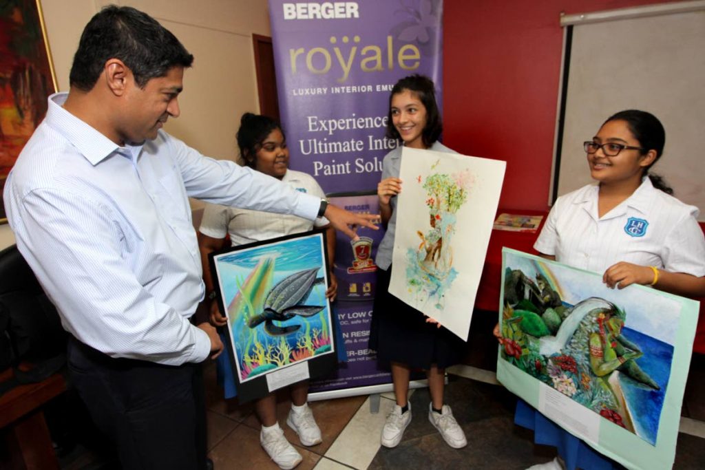 Yudhister Samaroo, general manager of Berger Paints (Trinidad) Ltd, chats with competition winners Alyssa Hosein of Lakshmi Girl’s Hindu College, from left, Roisin Brady of St Joseph Convent (PoS), and Hemalini Boodram of Lakshmi Girl’s Hindu College as they hold their winning art pieces. PHOTO BY ROGER JACOB