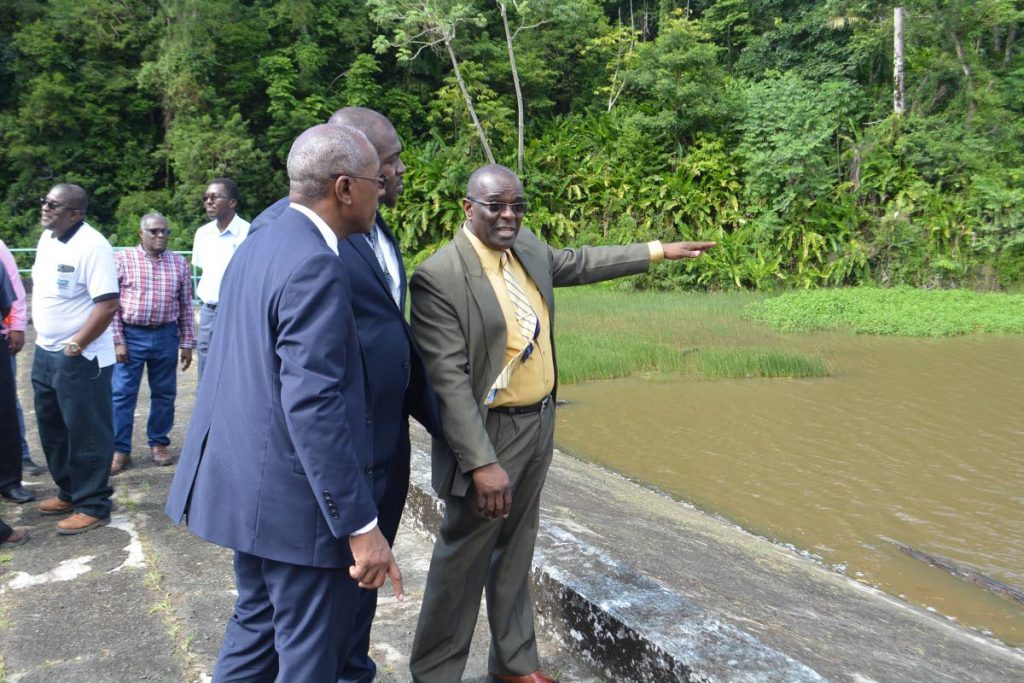 Public Utilities Minister Robert Le Hunte, left, and Public Utilities Secretary Clarence Jacob, listen to Water and Sewerage Authority chairman, Ellis Burris, right, during a visit to the Hillsborough Dam last Monday.