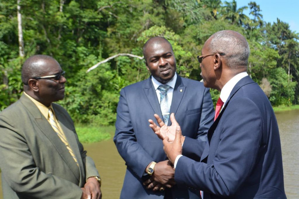 Public Utilities Secretary Clarence Jacob, centre, listens as Public Utilities Minister Robert Le Hunte, right, makes a point during a visit to the Hillsborough dam last week Monday. At left is Water and Sewerage Authority chairman, Ellis Burris.