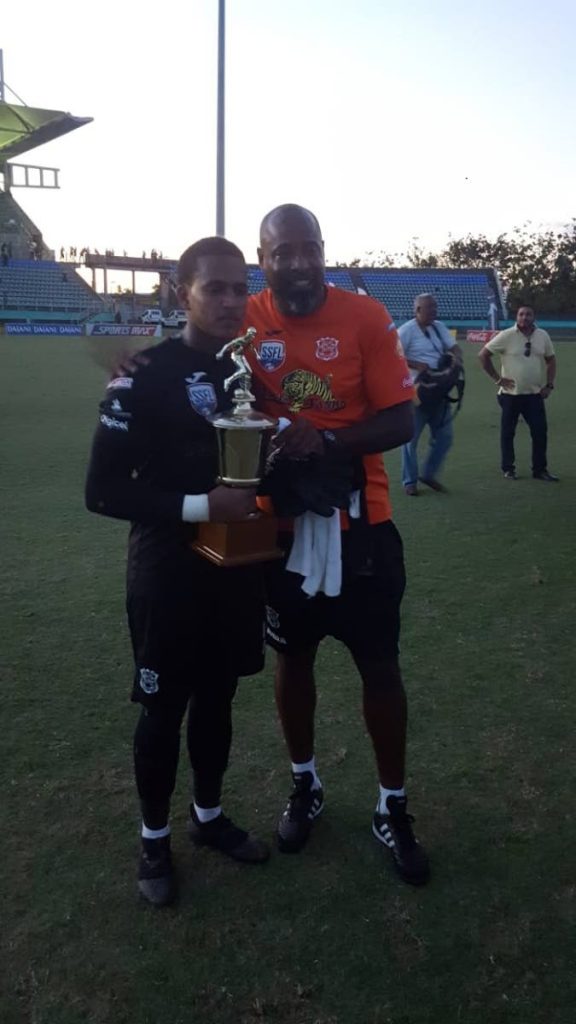 Naparima captain and goalie Levi Fernandez, left, poses with assistant coach and former national player Clayton Ince after winning the Coca Cola South Intercol final yesterday. 