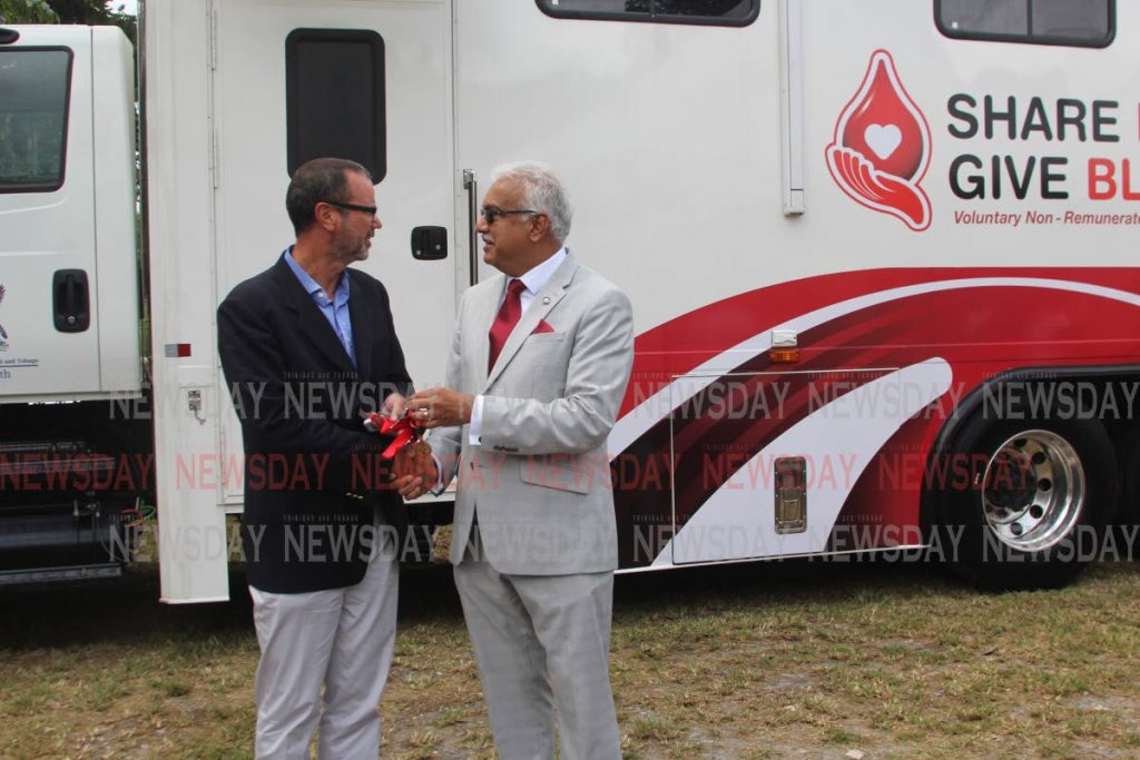 Minister of Health Terrence Deyalsingh, hands over the keys to the mobile bloody unit to Alfred Bell, president of friends of the blood bank Association. Photo by Enrique Assoon