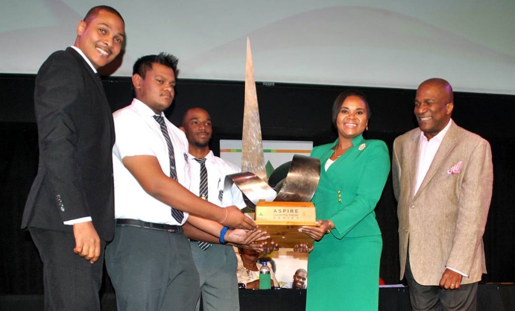 Minister of Sport and Youth Affairs, Shamfa Cudjoe, presents the JA Leadership Debate Series championship challenge trophy to Vashisht Ramoutar (second from left), lead debater for Naparima Boys College Team A and his fellow student, Joel Beckles. At left is  Nigel De Freitas, vice president of the Senate, and J Errol Lewis, JA executive director.