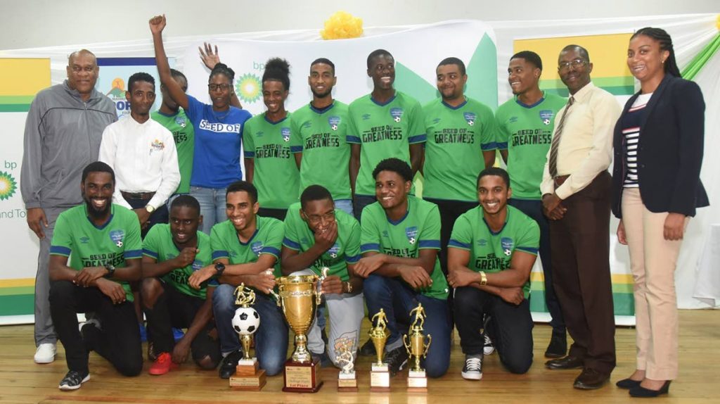 Seed of Greatness players celebrate their senior league championship title at the prize distribution function of the 2018 BPTT Razack Jan Memorial Mayaro Football league at the Mayaro Resource Centre on Saturday. Sharing in the occasion are (back row) Matthew Pierre (left), BPTT; Jameson Riguues (second from left), All Mayaro Sports Foundation; Rachael Caines (right), BPTT; and Patrice Charles, Minstry of Sport.