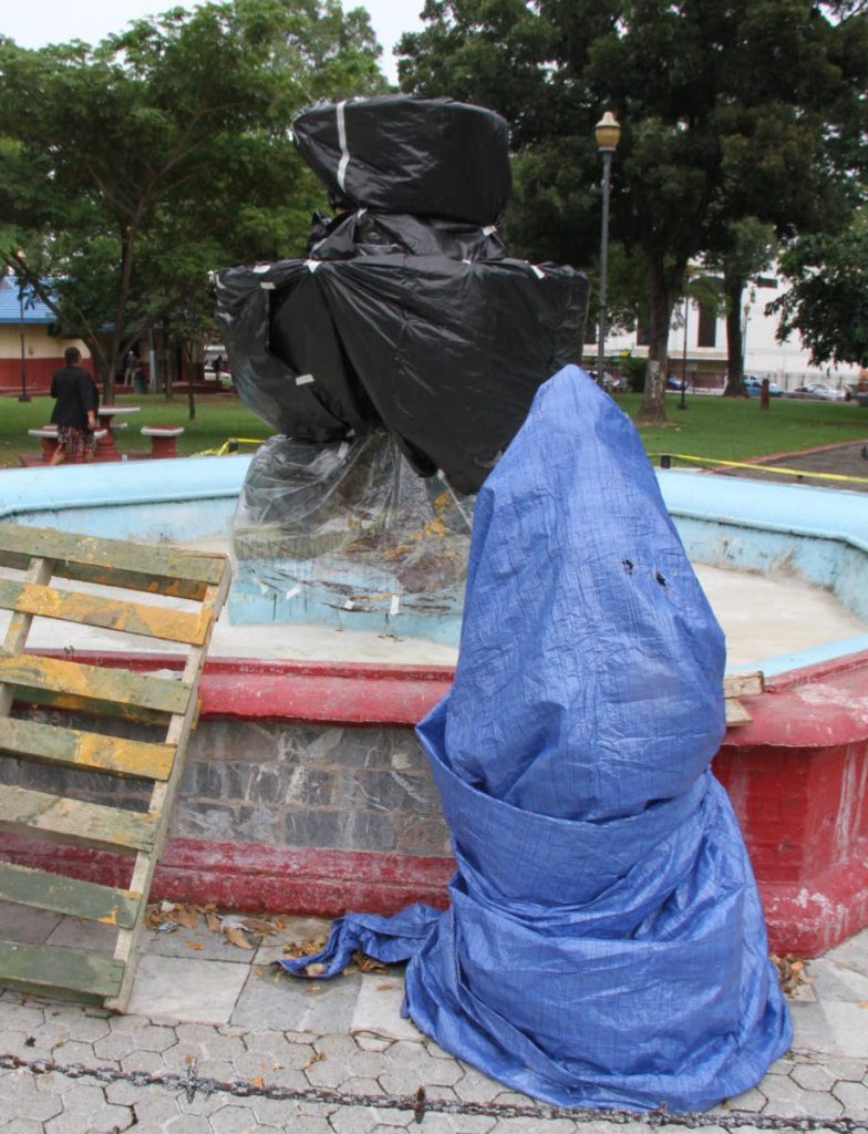 UNDER COVER: The iconic statue and fountain, secured under a tarpaulin, as restoration works continue at Woodford Square, Port of Spain 

Tuesday, November 27, 2018. PHOTO BY ROGER JACOB.  