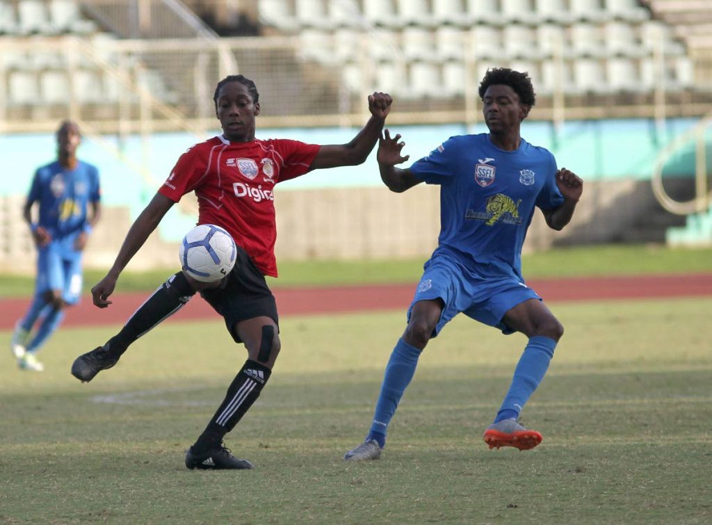 St Anthony’s Quinn Fredrick,left, and Naparima College’s Isa Bramble, vie for the ball during the semi-final encounter yesterday, at the Manny Ramjohn Stadium, Marabella. Naps won 2-0.