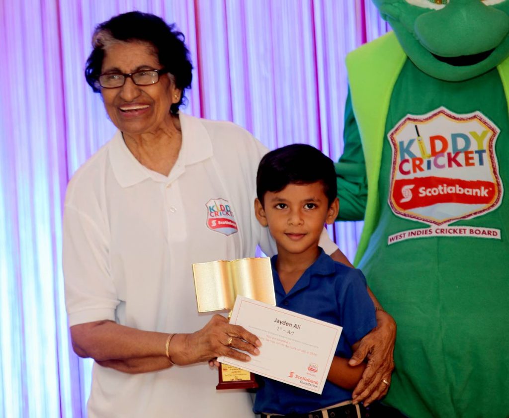 San Francique Presbyterian’s Jayden Ali is presented with the top prize in the art competition by Zalayhar Hassanali,during Scotiabank’s Kiddy Cricket Awards held yesterday, at Kampo Vibes Restaurant, Chaguanas.