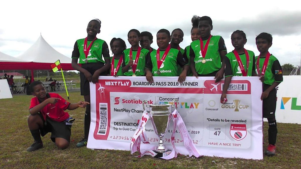 Members of the Siparia Boys RC with a couple girl representatives pose after capturing the CONCACAF NextPlay Cup yesterday.
