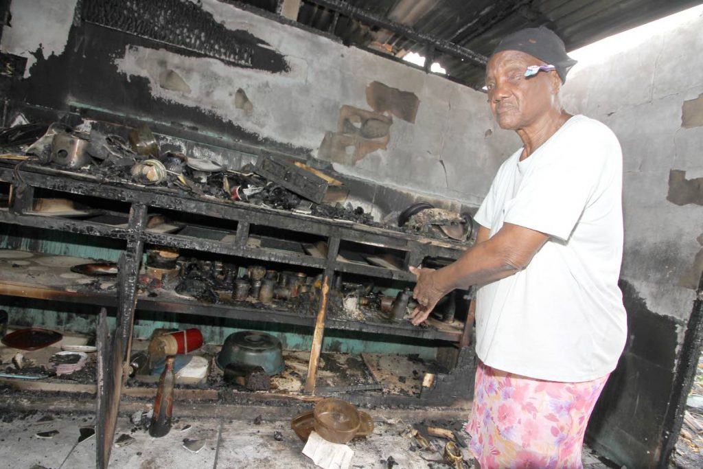 Jean Blades, 73, shows the burnt remains of her kitchen yesterday.  She was one of several people left homeless after fire razed through the Sea Lots community on Friday last week.