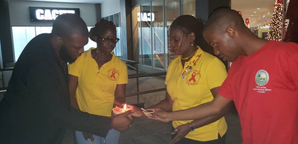 Minority Councillor and founder of the Imani Bet Knesset Foundation, Dr Faith BYisrael, second from right, lights deyas with supporters for a vigil to commemorate World Aids Day at the Gulf City mall, Lowlands on Friday.