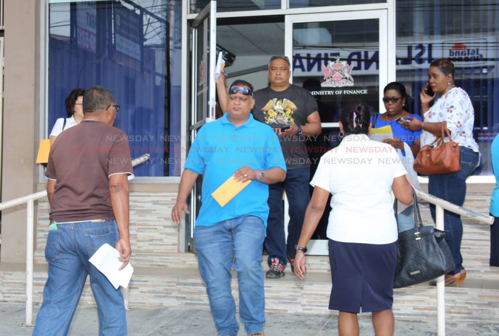 Petrotrin workers is seen walking out with their envelopes which  they received from Inland Revenuwe this morning. Photo by Vashti Singh 