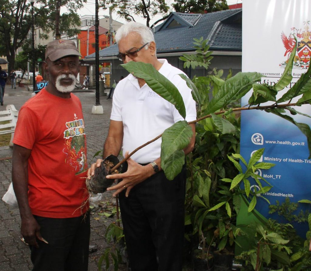 SUGAR APPLE: Minister of Health, Terrence Deyalsingh, gives  sugar apple plant to a passerby, during the  the launch of TT Moves, Brain Lara Promenade.