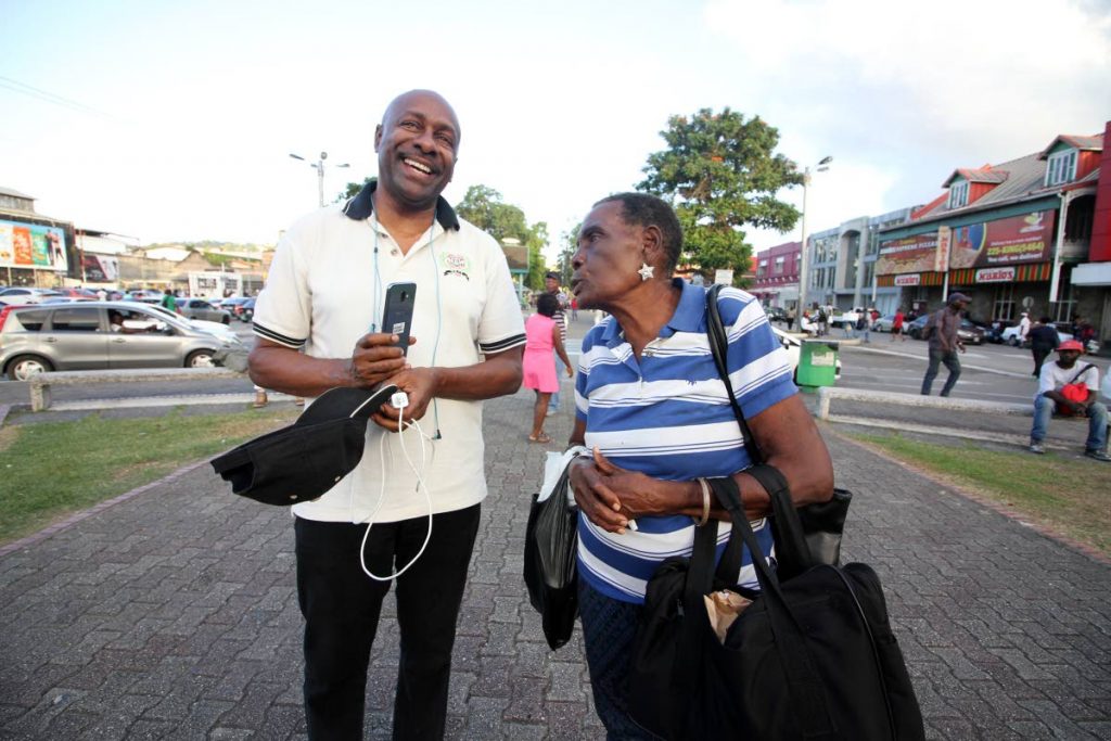 Social activist Errol Fabien listens to a woman who stopped to give him words of encouragement during his 20-hour vigil in support of Petrotrin and Caroni workers at the Cipriani statute, Cipriani roundabout, Port of Spain on Friday. He ended his vigil yesterday. PHOTO BY ROGER JACOB