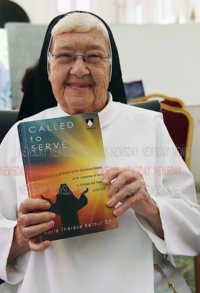 Sr Marie Thérèse Rétout OP with a copy of her book Called to Serve which tells the story of the Dominican Sisters of St Catherine of Siena in TT. PHOTO BY AZLAN MOHAMMED