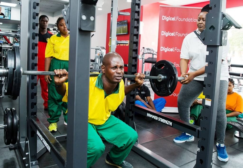 Special Olympics of TT (SOTT) powerlifter  Cuthbert Joseph concentrates as he squats with the barbell on his back while other teammates look on at D’ Dial Fitness Club, Long Circular Mall, St James.