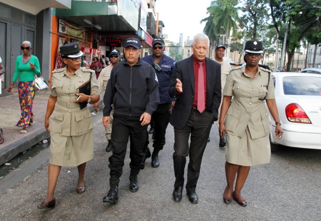 WALKING THE BEAT: Commissioner of Police Gary Griffith, 2nd from left, was accompanied on a walk of downtown Port of Spain yesterday by Snr Supt (PoS Division) Floris Hodge-Griffith, right, other officers and PoS Mayor Joel Martinez, 2nd from right. PHOTO BY SUREASH CHOLAI 