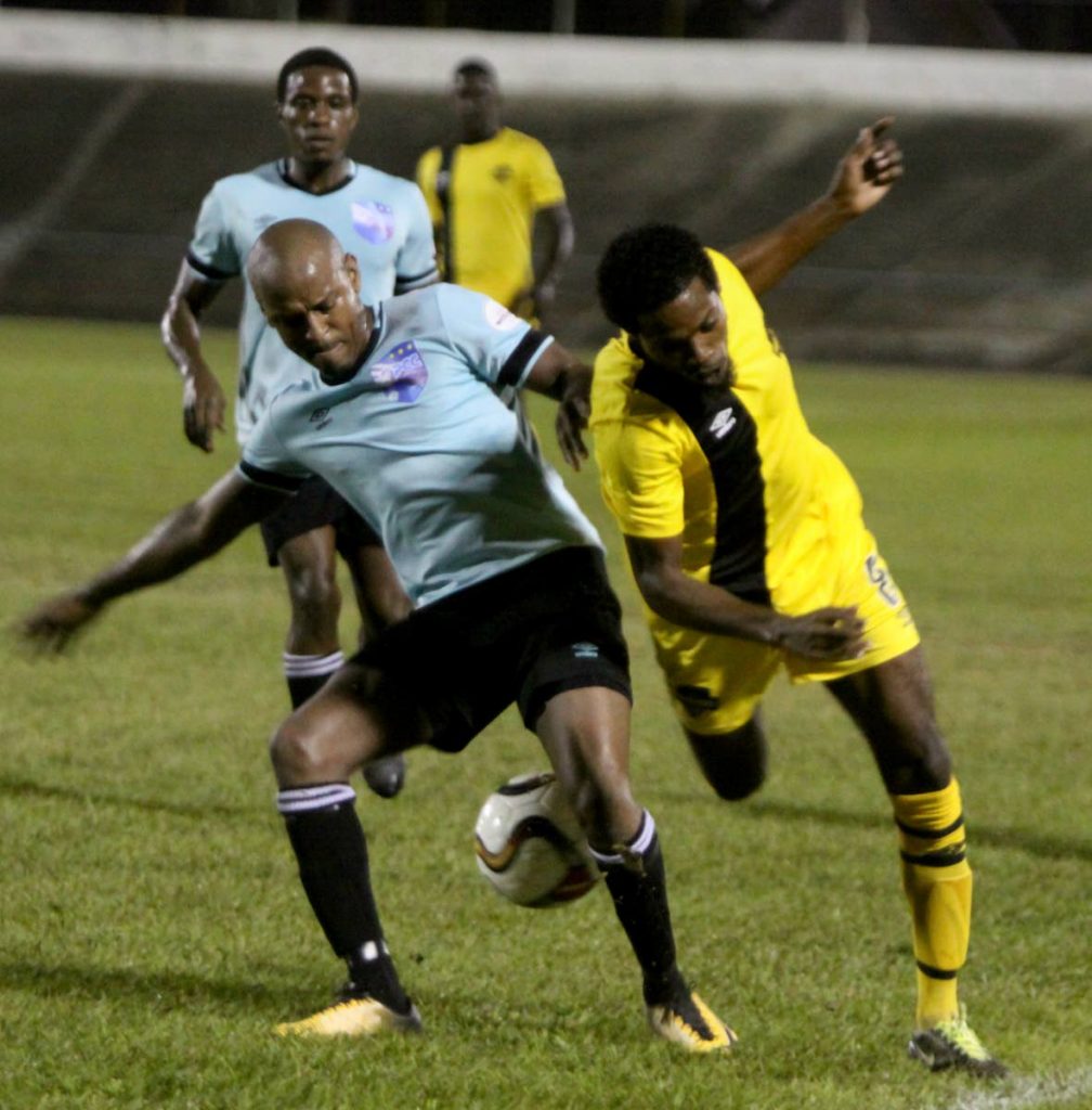 Kristian Meloney of Cunupia FC, right, is fouled by Kashif Clarke of Queen's Park in the Super League Cup final at the Arima Velodrome on Sunday.