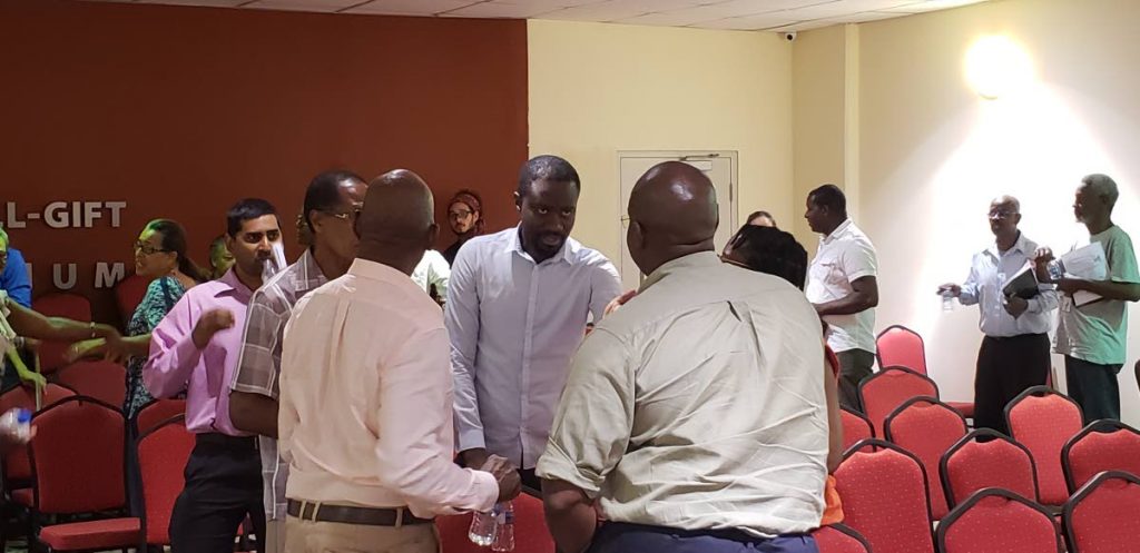 Minority Assemblyman Farley Augustine (facing camera) chats with participants at a discussion on the Memorandum of Understanding (MOU) between Government and Sandals Resorts International (SRI) at the Scarborough library last Thursday.